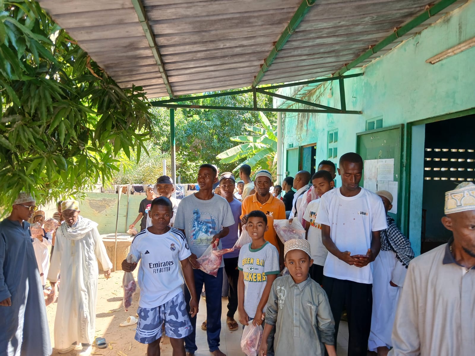 Hommes et jeunes du village repartant avec leur part de viande de l'Aïd